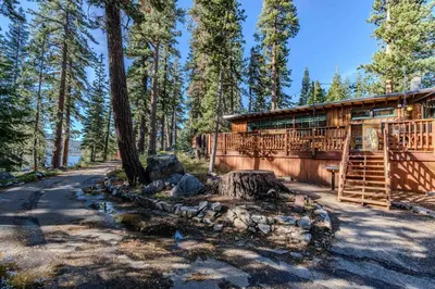 a log cabin with a tree stump in front of it at Kit Carson Lodge in Kit Carson