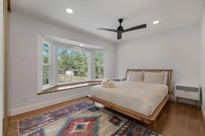 a bedroom with a bed with a ceiling fan and windows at New Listing - 5bd 3ba Retreat for a large group in Groveland