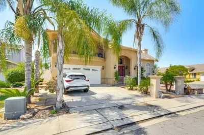 a car parked in front of a house with palm trees at Golf, Fish and More Cozy Safari Unit in Atwater! in Atwater