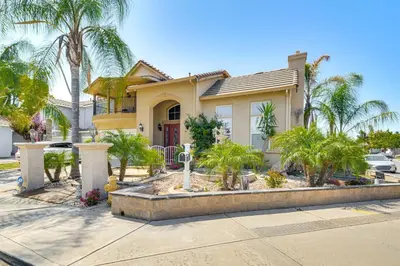 a house with palm trees in front of it at Golf, Fish and More Cozy Safari Unit in Atwater! in Atwater