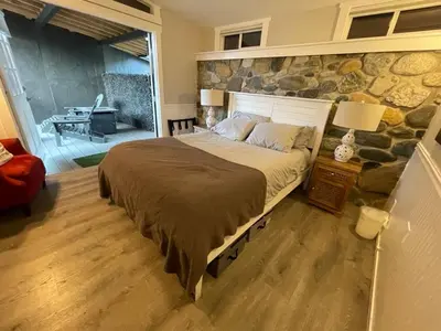 a bedroom with a large bed with a stone wall at Kaweah River Cabin - Pool, Hot Tub, Movie Projector in Three Rivers