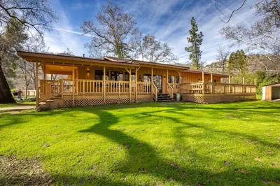 a house with a large yard in front of it at Serene Riverfront Home - 150 yds from the River in Three Rivers