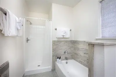 a white bathroom with a tub and a shower at Serene Riverfront Home - 150 yds from the River in Three Rivers