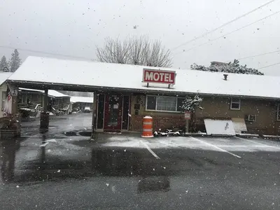 a motel is covered in snow in a parking lot at colfax motorlodge in Colfax