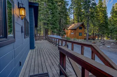 a wooden walkway leading to a cabin in the woods at Laid-Back Tahoe Stay Walk to Lake & EV Charger in Homewood
