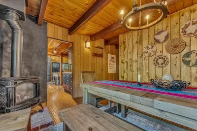 a living room with a fireplace and a wooden wall at Laid-Back Tahoe Stay Walk to Lake & EV Charger in Homewood
