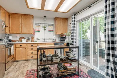 a kitchen with wooden cabinets and a large window at Hike, Swim and Golf Home Near Dtwn Twain Harte in Twain Harte