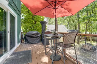 a patio with a table and chairs and an umbrella at Hike, Swim and Golf Home Near Dtwn Twain Harte in Twain Harte