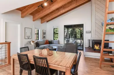 a living room with a wooden table and a fireplace at Northstar 2BR Walk to Village Bike Hike Rec Center in Truckee