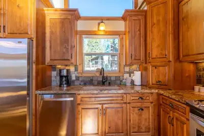 a kitchen with wooden cabinets and a sink and a window at Kings Beach Family Retreat - Lake Views and Hot Tub in Kings Beach