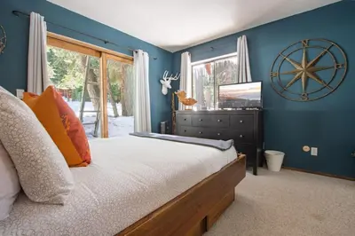 a bedroom with a large bed with blue walls at A-Frame Cabin - Hot Tub , BBQ , Family Fun in Tahoe Vista