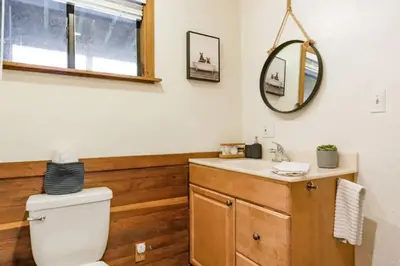 a bathroom with a toilet and a sink and a mirror at Charming Kings Beach Cabin, Hot Tub, Walk to Lake in Kings Beach