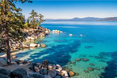 a large body of water with trees and rocks at Charming Kings Beach Cabin, Hot Tub, Walk to Lake in Kings Beach