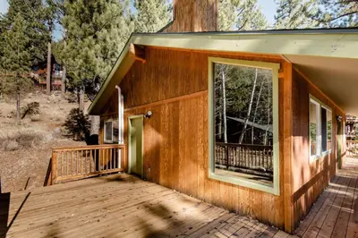 a house with a large window on a deck at Walk to Palisades Village Pet Friendly 2BR Chalet in Olympic Valley