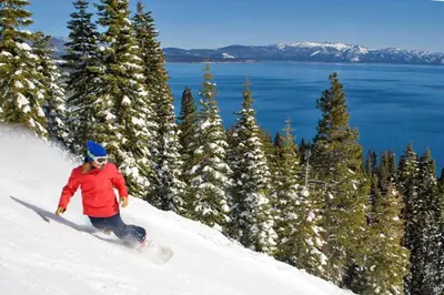 a person riding a snowboard down a snow covered slope at Walk to Lake West Shore Cabin Hot Tub DogOK EVplug in Homewood
