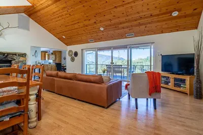 a living room with a couch and a television at Riverfront Serenity with Stunning Views in Mariposa