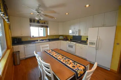 a kitchen with a table and a white refrigerator at Cozy Cabin with Boat Slip Winter SpecialEnds512 in Bass Lake