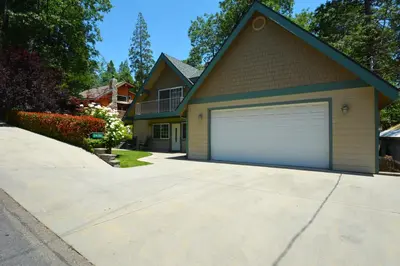a house with a garage on a driveway at Cozy Cabin with Boat Slip Winter SpecialEnds512 in Bass Lake