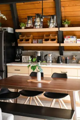 a kitchen with a wooden table with chairs and a table at Modern A Frame,20min Yosemite,Sunset View, PetOkay in Oakhurst