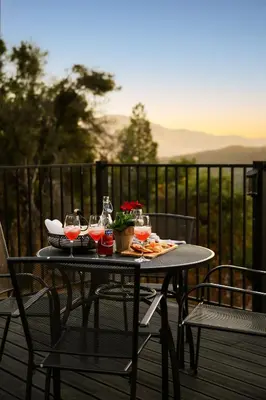 a table with drinks and snacks on a balcony at Modern A Frame,20min Yosemite,Sunset View, PetOkay in Oakhurst