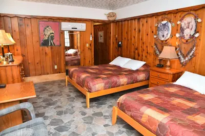 a hotel room with two beds and a table at The Kern Lodge in Kernville