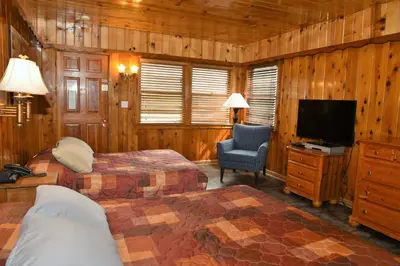a bedroom with two beds and a flat screen tv at The Kern Lodge in Kernville