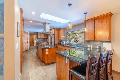 a kitchen with wooden cabinets and a counter top at Tranquil Stay Sauna, Rooftop and Nature Views in Incline Village