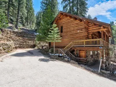 a log cabin with a driveway in front of it at Yosemite Log Cabin-Rustic Charm-Sleeps 8 in Yosemite West