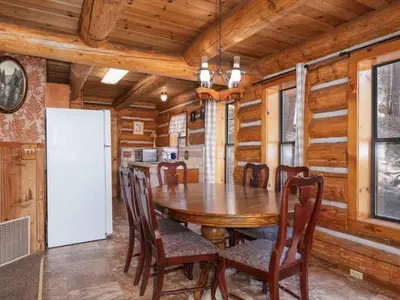 a dining room with a wooden table and chairs at Yosemite Log Cabin-Rustic Charm-Sleeps 8 in Yosemite West