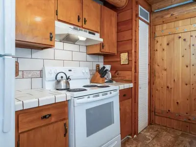 a kitchen with a stove and a tea kettle at Yosemite Log Cabin-Rustic Charm-Sleeps 8 in Yosemite West