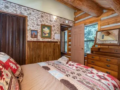 a bedroom with a bed and a dresser in a cabin at Yosemite Log Cabin-Rustic Charm-Sleeps 8 in Yosemite West