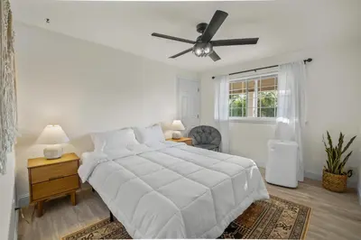 a white bedroom with a bed and a ceiling fan at MtnCity Views 4BR Firepit FamilyRetreat NearUNR in Reno