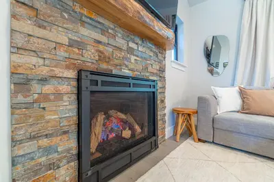 a brick fireplace in a living room with a couch at Elegant Tahoe Escape Comfort and Style Combined in Glenbrook