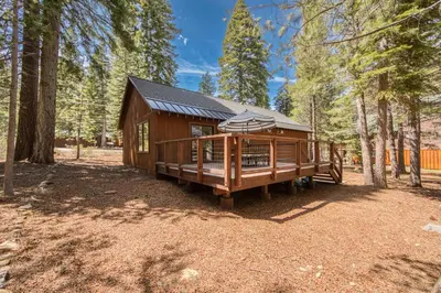 a small wooden cabin in the woods with trees at Charmed Cabin at Tahoe Donner by Tahoe Getaways - 2BR w HOA Access in Truckee