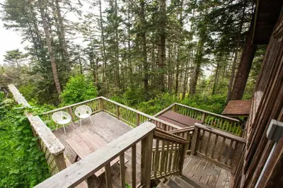a deck with a table and chairs on it at Redwoods Oceanview Retreat
