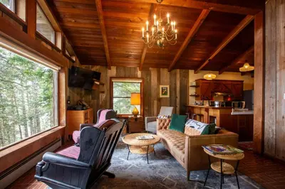 a living room with a couch and chairs and a chandelier at Redwoods Oceanview Retreat