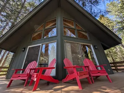 three red chairs sitting in front of a cabin at Mountain Haven Near Kirkwood Resort! in Pioneer