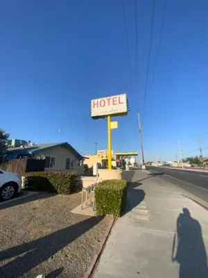 a sign for a hotel on the side of a street at Hotel Paisano in Reedley