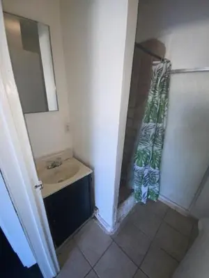 a small bathroom with a sink and a mirror at Hotel Paisano in Reedley