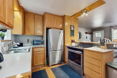 a kitchen with wooden cabinets and a stainless steel refrigerator at The Bear's Den in South Lake Tahoe