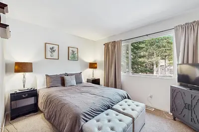 a bedroom with a bed and a large window at The Bear's Den in South Lake Tahoe