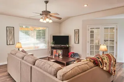 a living room with a couch and a table at Scenic Mountain Views w Heated Pool, Game Room, and Hottubs in Oakhurst