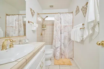 a white bathroom with a sink and a toilet at Scenic Mountain Views w Heated Pool, Game Room, and Hottubs in Oakhurst