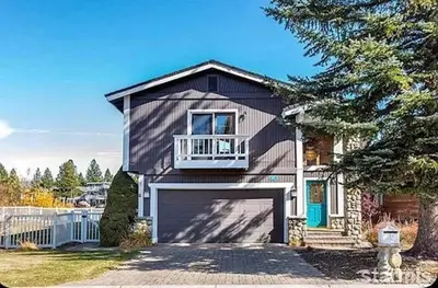 a large house with a garage and a tree at 625 Alpine Drive home in South Lake Tahoe
