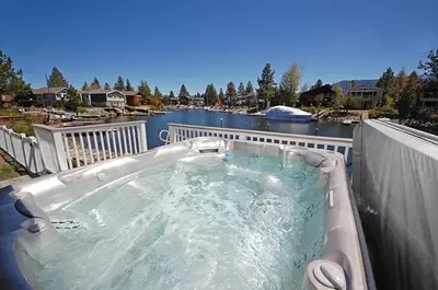 a hot tub on a balcony with a river at 625 Alpine Drive home in South Lake Tahoe