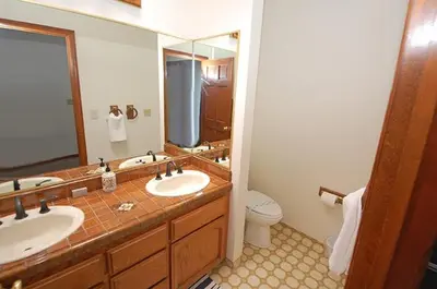 a bathroom with two sinks and a large mirror at 625 Alpine Drive home in South Lake Tahoe