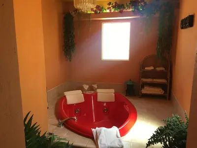 a red bath tub in a bathroom with a window at Shady Lady Bed and Breakfast in Scottys Junction
