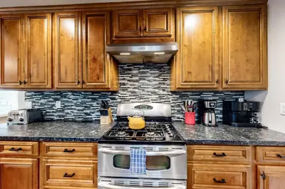 a kitchen with wooden cabinets and a stove top oven at Meadows Crossings in South Lake Tahoe