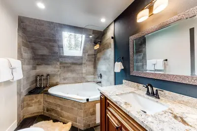 a bathroom with a tub and a large mirror at Meadows Crossings in South Lake Tahoe