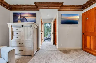 a hallway with a dresser and a tv on a wall at Homewood Hideaway Family Friendly plus EV Charger in Homewood